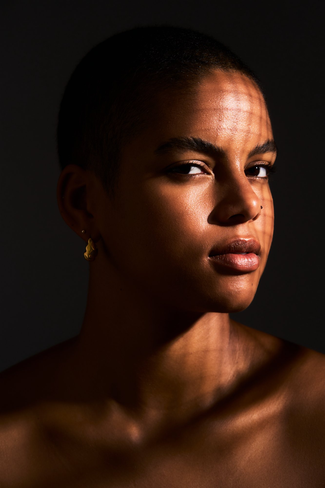 Warm dramatic close-up portrait with golden skin tones — séance photo Montréal